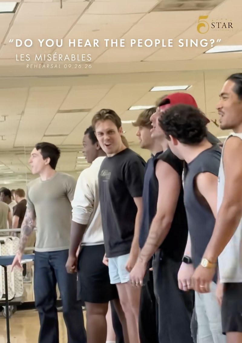 Les Misérables reel still: the men of the company singing in rehearsal